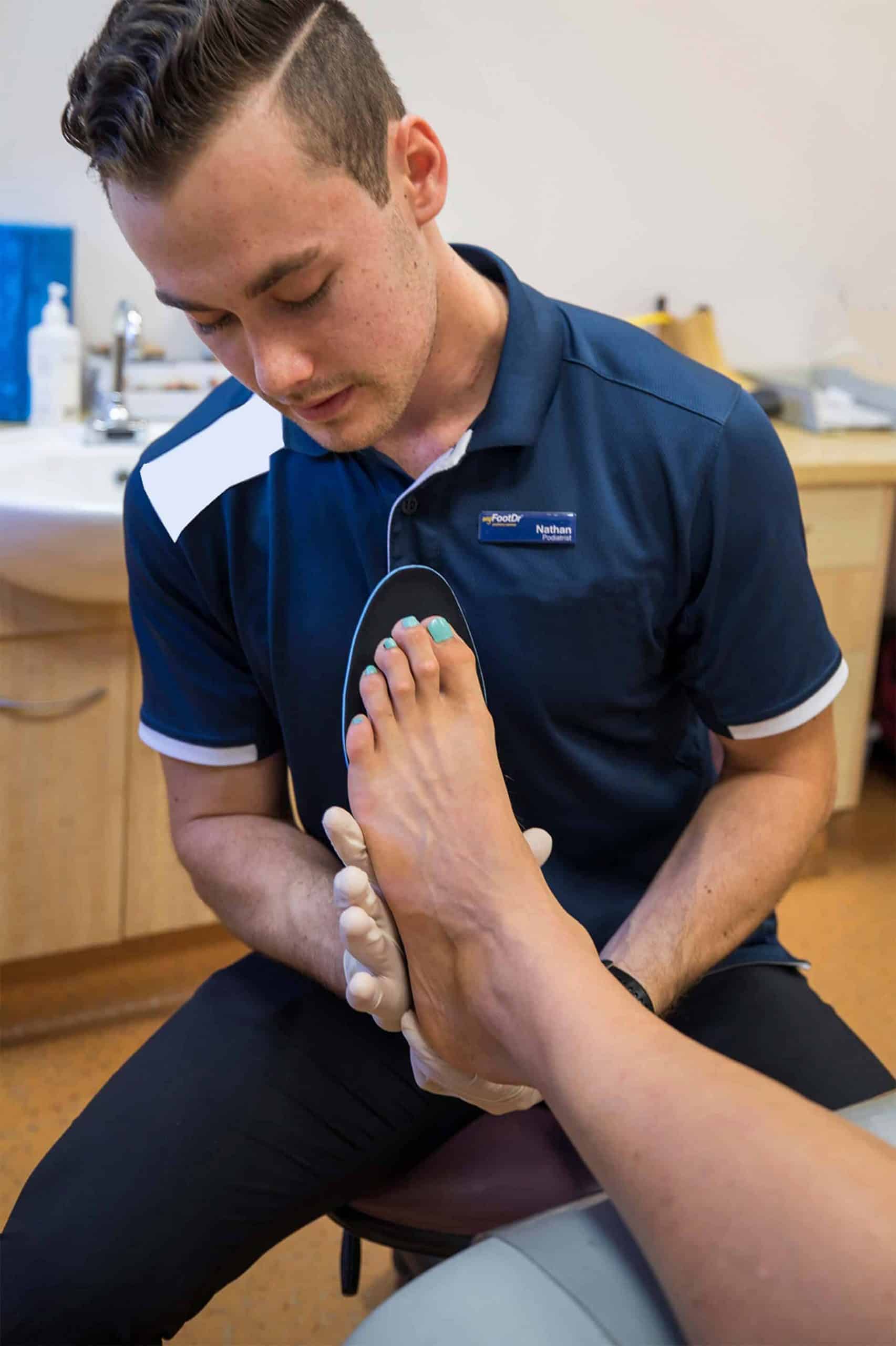 MyFootDr staff checking a patient's foot for custom foot orthotics